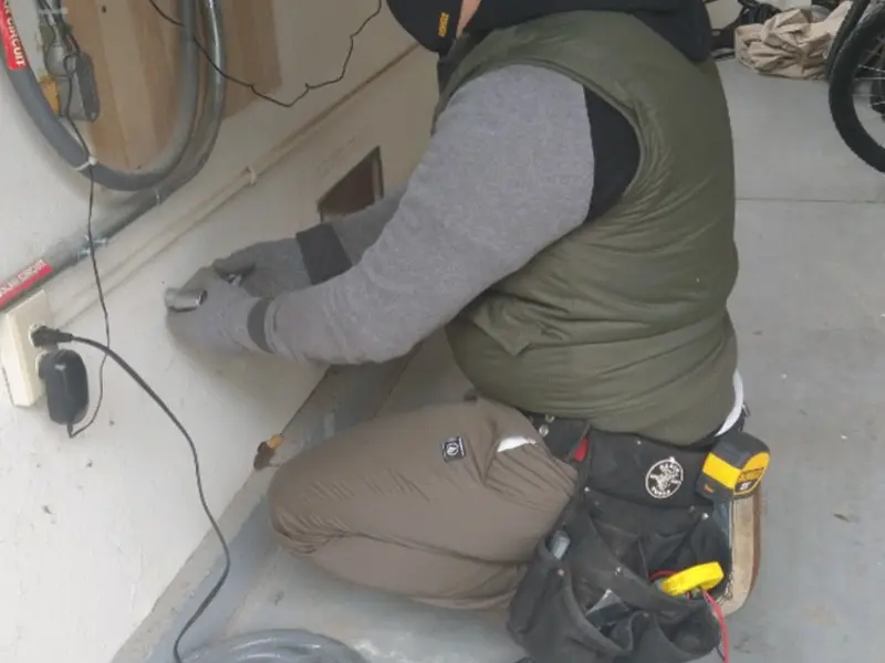 Electrician performing outlet wiring in a San Leon garage
